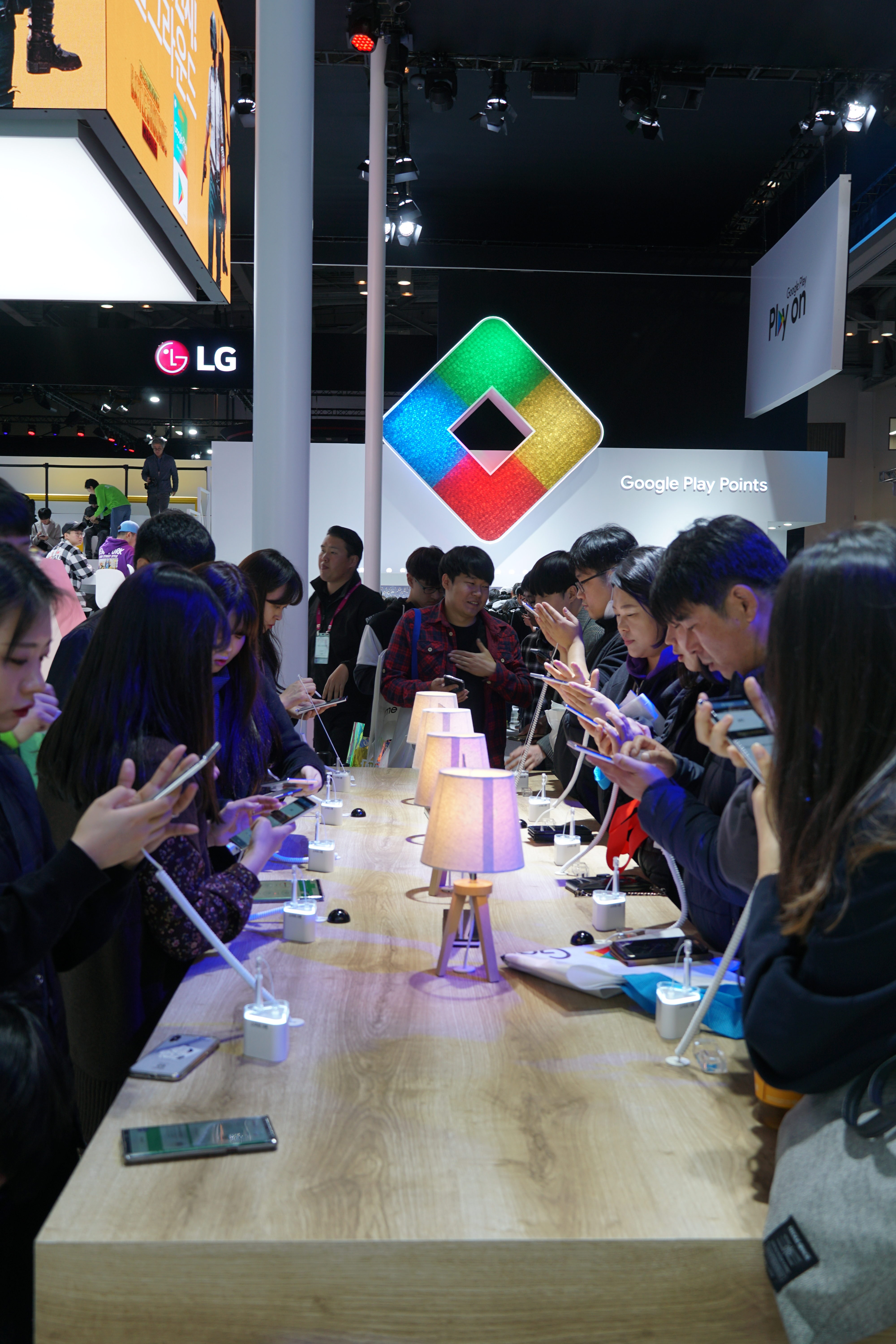 A group of G-STAR attendees, part of a growing mobile-first generation, stare intently at phones and tablets.