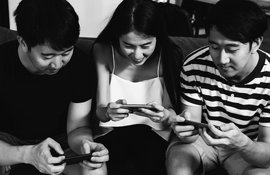 Three gamers on handheld video games