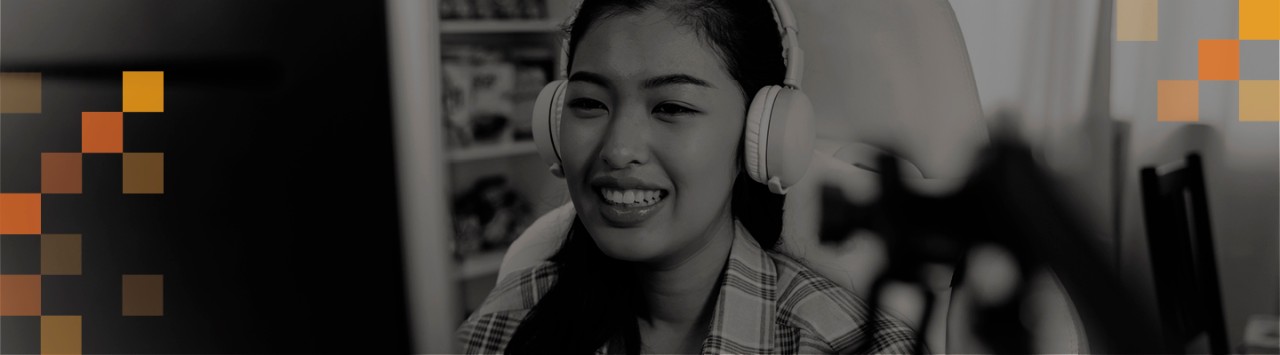 A woman smiles at a computer monitor.
